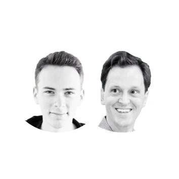 Black and white photo of two men, one younger and one older, smiling.